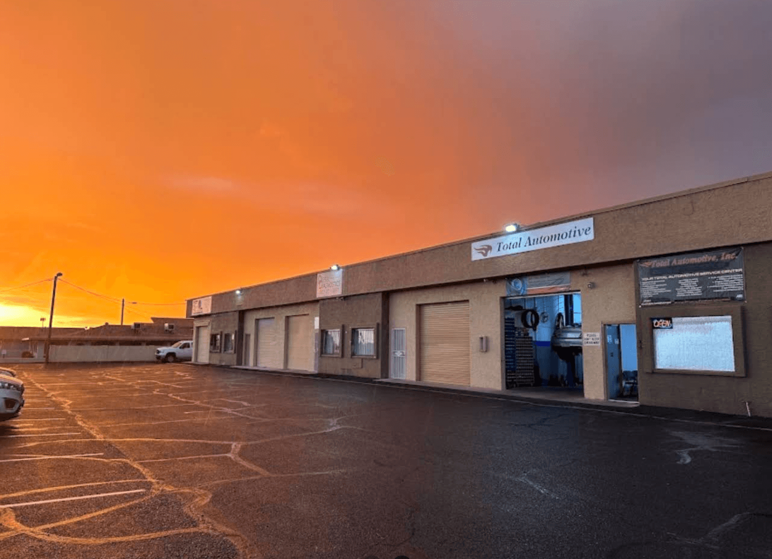 The Total Automotive & Performance shop in Apache Junction under an Arizona sunset